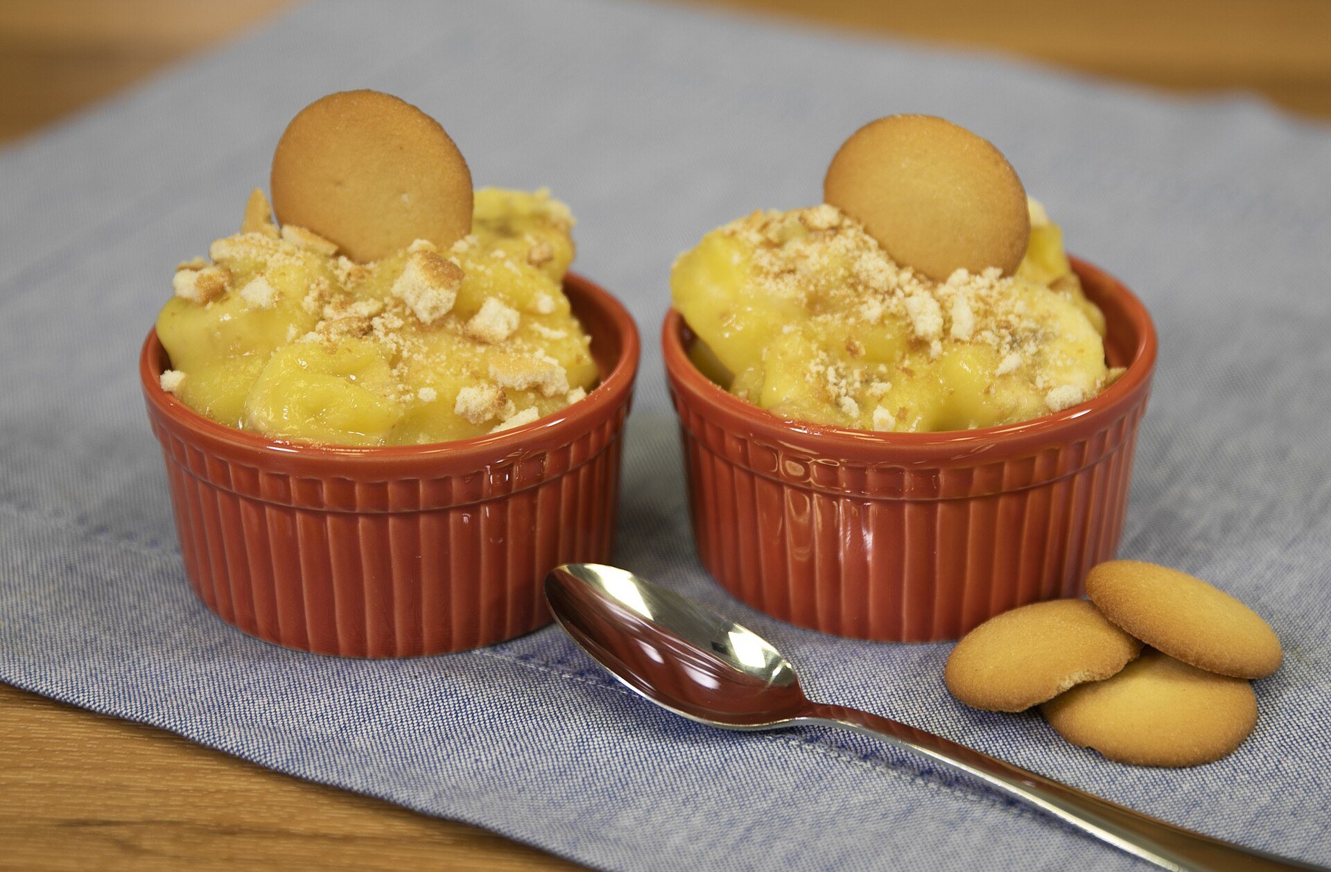 Banana pudding in orange ramekins topped with vanilla wafers