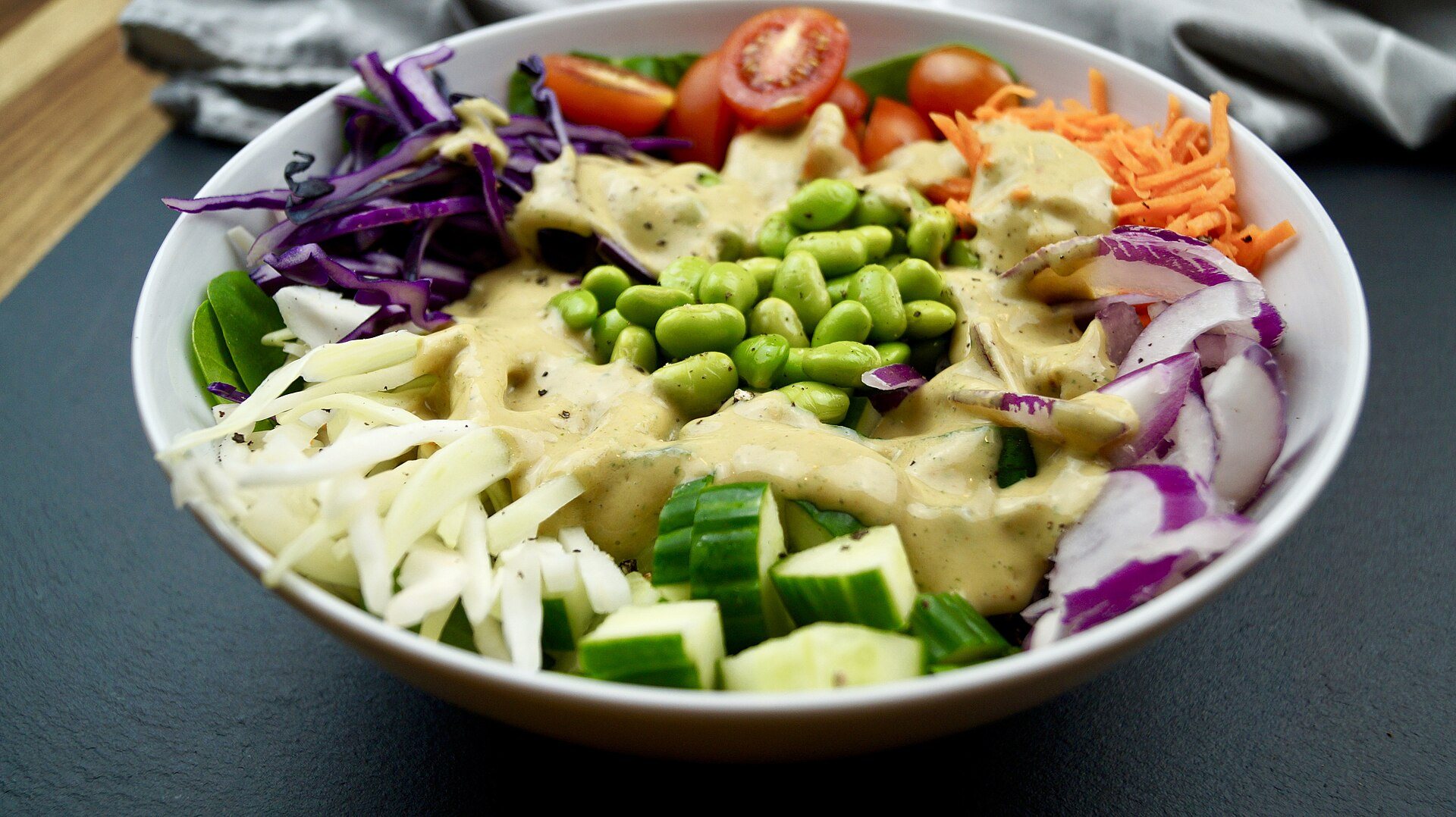 Vegan Buddha bowl with edamame, cucumber, red cabbage, carrots and a creamy dressing