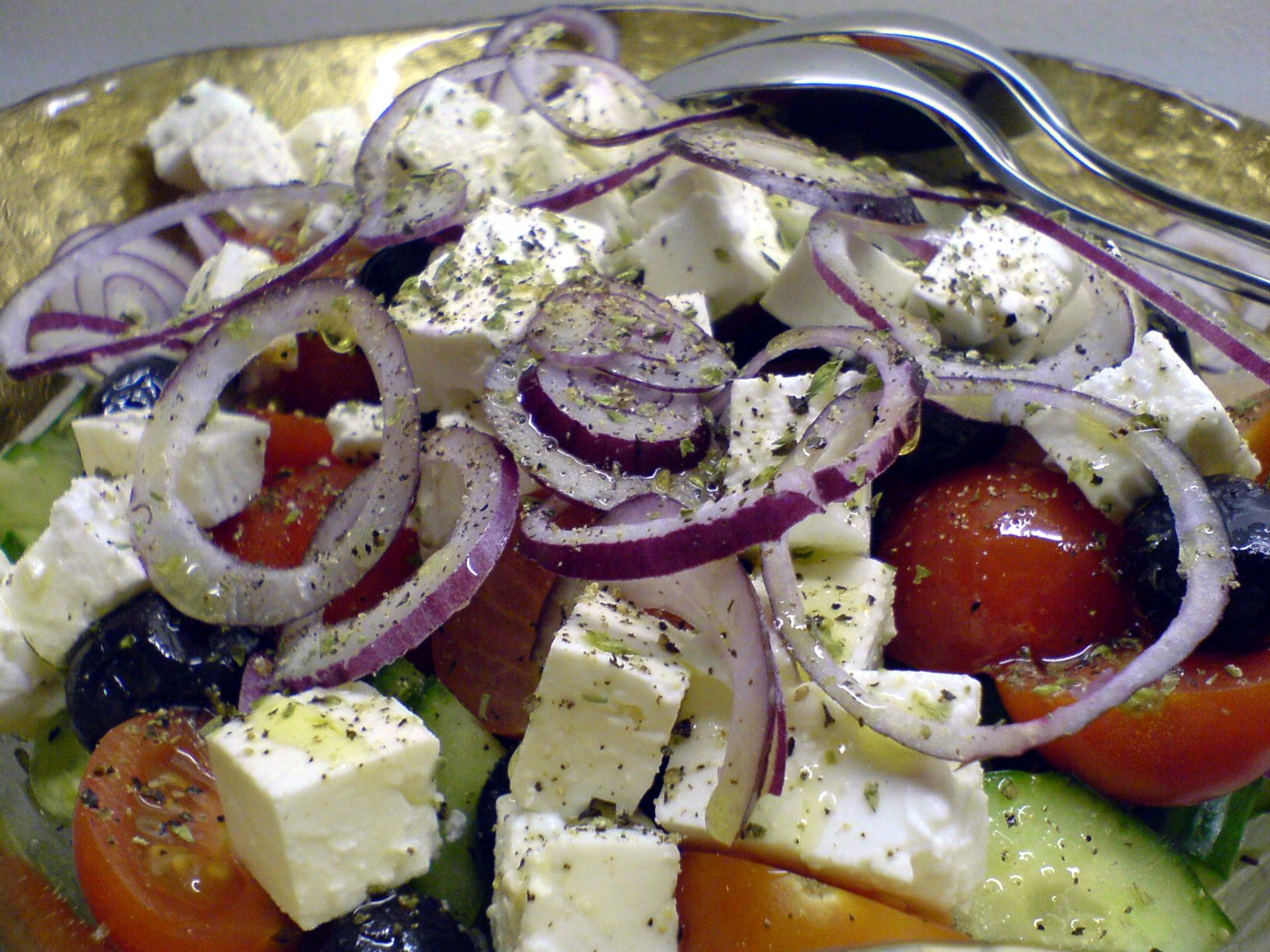 Greek salad with cubes of feta, tomatoes, cucumber, olives and red onion rings