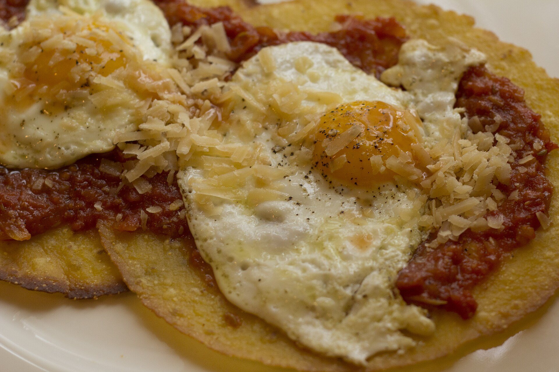 Huevos rancheros: fried eggs on corn tortillas with red salsa and grated cheese